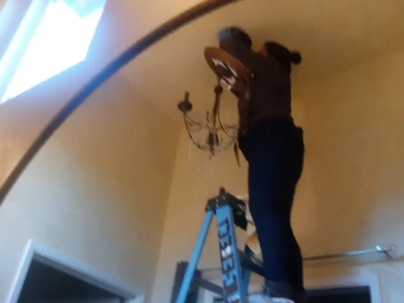 Electrician installing a chandelier in a North Fork residence